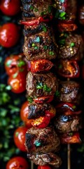 Fototapeta premium Close-up of barbecue beef shish kebab skewers with cherry tomatoes alternating on metal skewers.