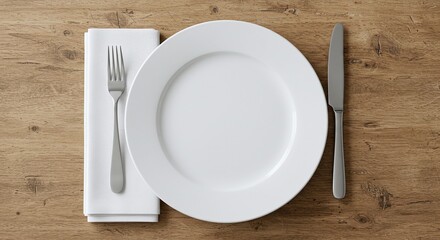 Place setting with white plate, fork and napkin, and knife on wooden table