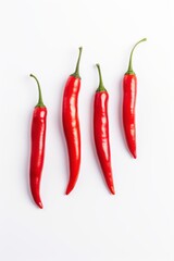 Four red chili peppers lying on white background