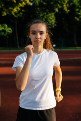 Teenage girl training at the stadium, doing track and field exercises, running and performing...