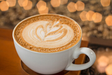 Latte art coffee with bokeh of lights on table, Dark tone.