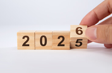 2026 Happy New Year. Wooden cube block change from 2025 to 2026 on blue. Concept 2026 New Year...