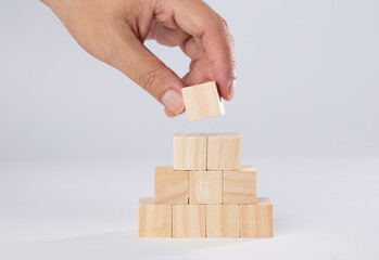 Hand taking one block from wooden blocks isolated on white background