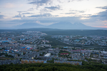 Morning cityscape. Top view of the buildings and streets of the city. Residential urban areas at twilight at dawn. Volcanoes in the distance. Petropavlovsk-Kamchatsky, Kamchatka, Far East of Russia.