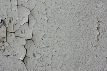Peeling paint on the wall. Old concrete wall with cracked flaking paint. Weathered rough painted...