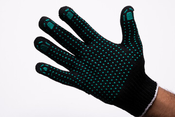 Black safety work glove with green rubber grip dots on white background