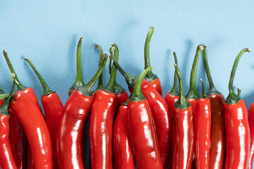 Sharp and Spicy Red Chilies Top View on Blue Background