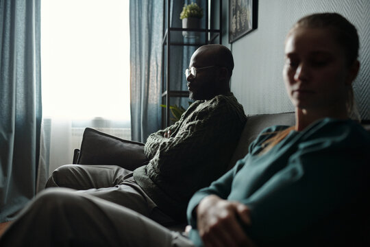 Husband and Wife Sitting with Arms Crossed At Psychologists