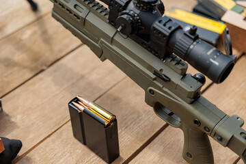 Close-up of carbine cartridges. Loaded weapon clip. Weapons in the background.