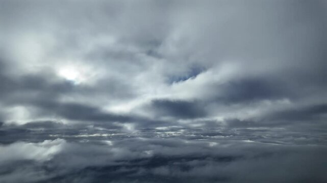 POV flying between layers of fluffy stratus clouds as seen from inside a jet cokpit. An immersive Pilot&rsquo;s View.