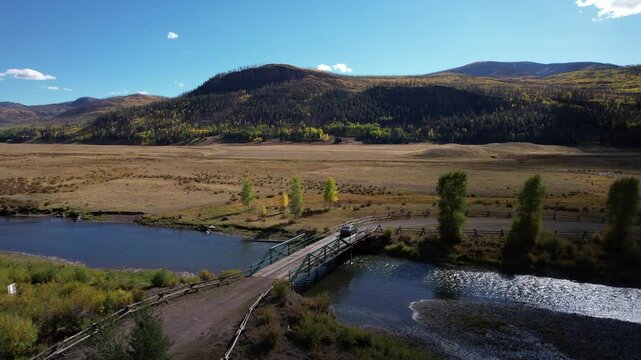 Drone Shot of Gracy Car Passing the Bridge Above Rio Grande River, Landscape of Colorado USA Outside South Fork