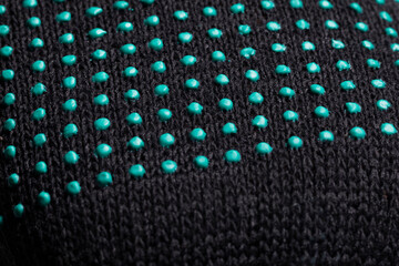 Close-up of black fabric with green rubber dots texture