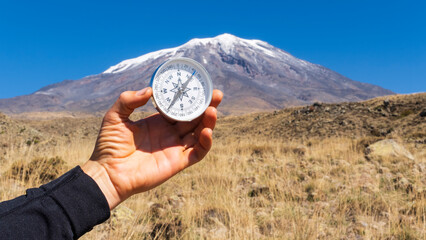 Round compass in hand on the background of Mount Ararat. Concept for travelling and active lifestyle.