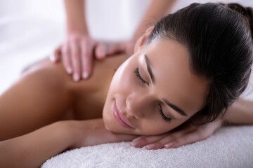 Obraz premium A young and beautiful woman is receiving a back massage from a professional therapist in the comfort of her own apartment, highlighting relaxation and beauty treatments for the body and face
