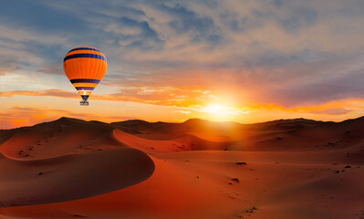 Hot air balloon flying over beautiful sand dunes in the Sahara desert - Sahara, Morocco