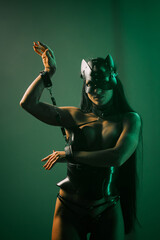 Dynamic pose of woman in cat mask and handcuffs under vibrant neon lights