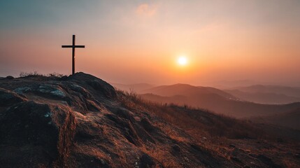 Christian cross standing on a hill during sunrise. Ascension of Jesus concept. Beautiful nature during sunrise or sunset. Cross on top of a hill, Christianity theme.