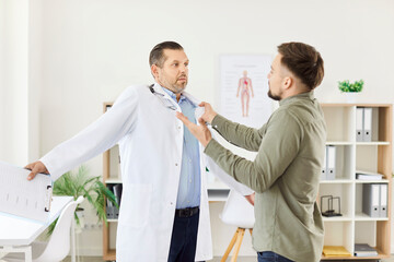 Plakat Angry male patient is threatening a doctor or nurse during a medical consultation in a hospital office. Aggression and the potential problems that can arise in a healthcare environment.