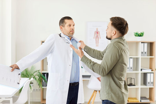 Angry male patient is threatening a doctor or nurse during a medical consultation in a hospital office. Aggression and the potential problems that can arise in a healthcare environment.