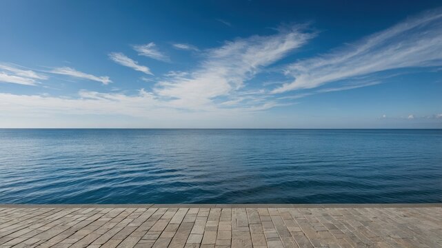 Serene seascape with calm waters and clear blue skies captures tranquility by the shoreline during late afternoon