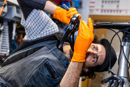 Bicycle mechanic repairing handlebars in workshop