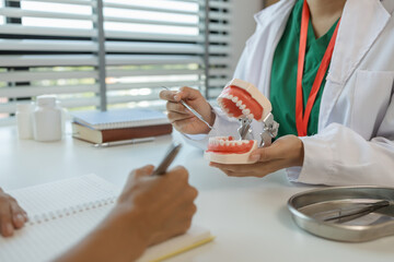 the dentist is explaining to the assistant how she will treat a patient with wisdom teeth, the two...