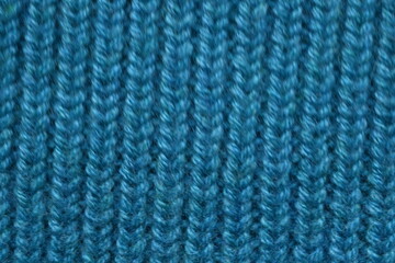 turquoise texture of knitted wool fabric as a background, teal smooth symmetrical lines of hand-knitted needlework pattern	
