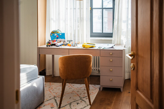 Children's room with a messy desk filled with toys and educational materials
