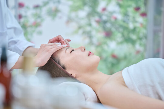 Young Asian Woman Receiving Facial Spa Treatment