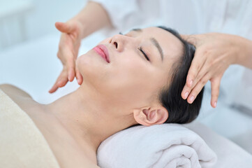 Female Spa Therapist Giving Head Massage to Woman in Wellness Center