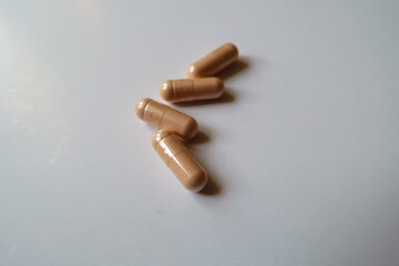 Macro of four pink capsules of palmitoylethanolamide dietary supplement