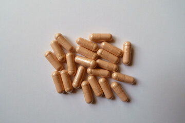 Top view of fistful of pink capsules of palmitoylethanolamide dietary supplement