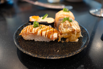 Japanese cuisine. Sushi set on a wooden plate over dark table background.