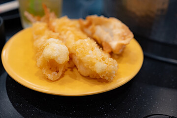 Closeup of Tempura Shrimp in a Yellow Plate