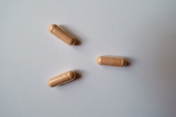 3 pink capsules of palmitoylethanolamide dietary supplement from above
