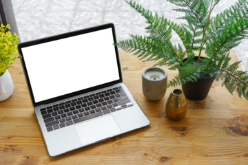 Laptop computer with white, transparent screen on wooden desk on wide window background. Office workspace, workplace in cafe or home. Mockup, template with copy space