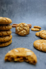Crunchy homemade oat cookies with sunflower seeds placed on a rustic grey stone background. Ideal for use in bakery promotion, healthy snack, and advertisements