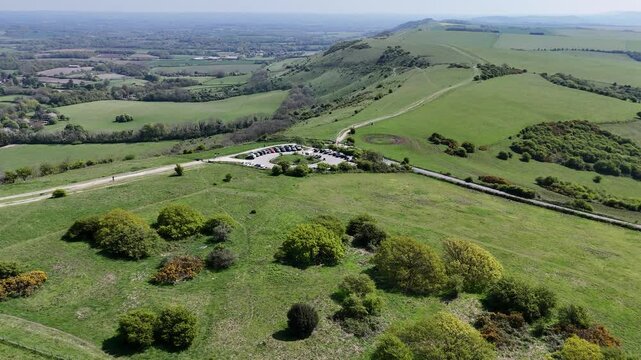 Stunning aerial footage of South Downs National Park, Sussex, featuring Ditchling Beacon. Rolling hills, countryside view. Perfect for travel, nature, and landscape projects.