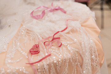 silk, chiffon, organza, lace, beads, rhinestones - fabrics for a wedding dress on the table of a seamstress in a studio. Close-up