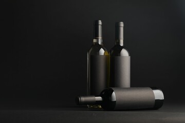 Bottles of wine on black background, space for text