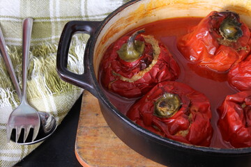 Stuffed bell peppers with meat and rice in tomato sauce, and spicy seasoning. homemade vegetarian dinner - baked colorful paprika stuffed with rice