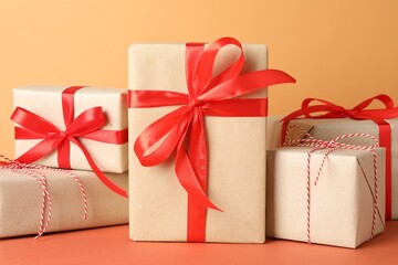 Many gift boxes wrapped in kraft paper on orange table