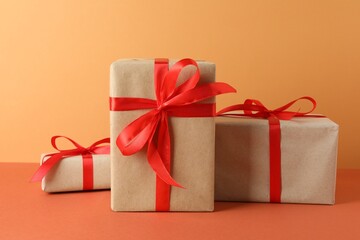 Many gift boxes wrapped in kraft paper on orange table