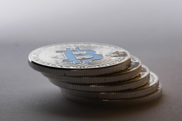 Cryptocurrency. Many silver bitcoins on light grey background, closeup