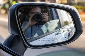 Photographer reflection in car rear view mirror