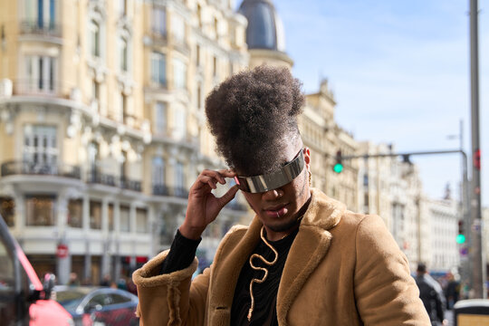Stylish afro gay man wearing futuristic visor in city center