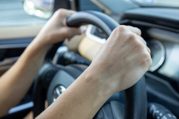 Naklejka premium Woman hands on steering wheel driving a car