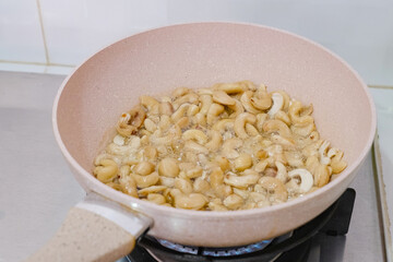 Frying cashew nuts in a teflon pan
