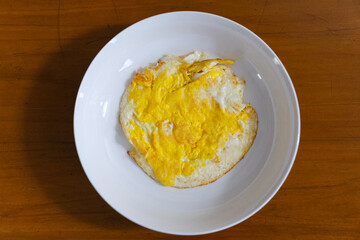Fried egg on white plate for breakfast
