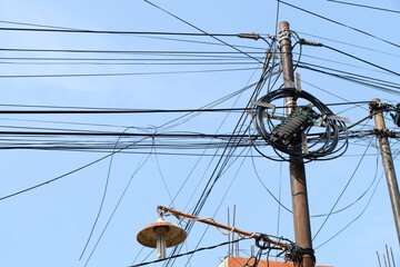 High voltage power pole against blue sky

